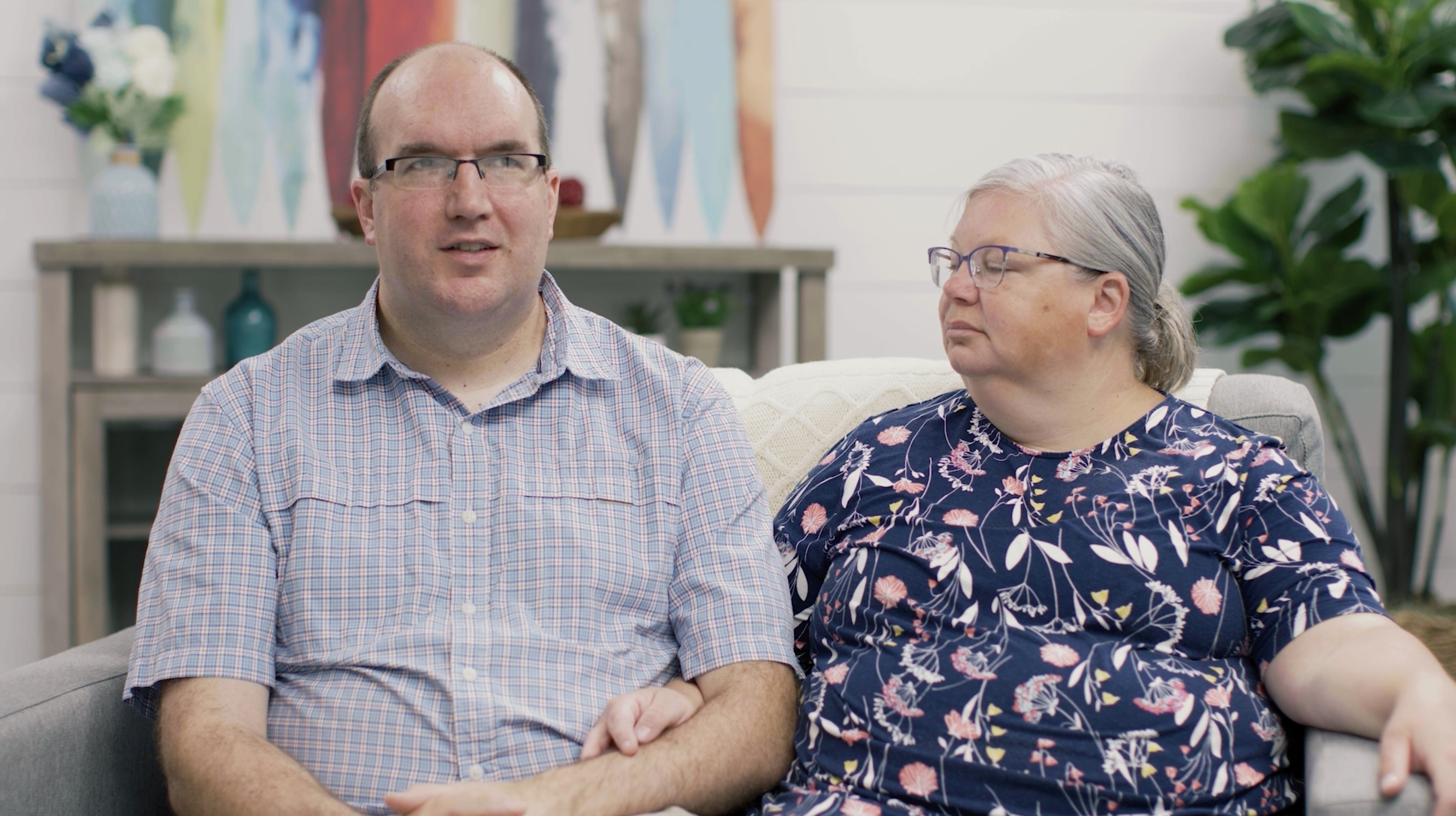 Refugee foster care parents (husband and wife) sitting on couch